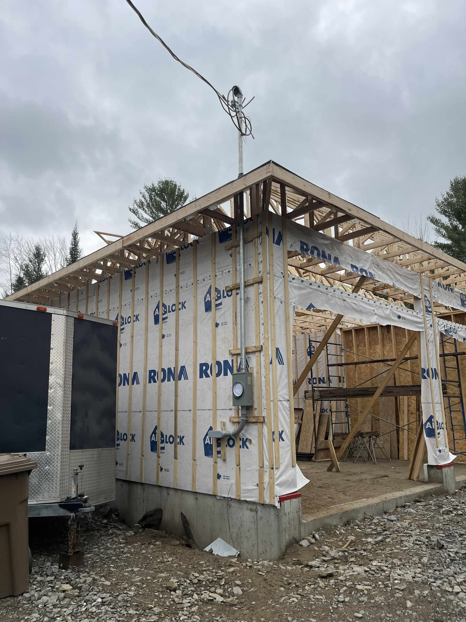 Wood frame under construction with the electrical service mast
