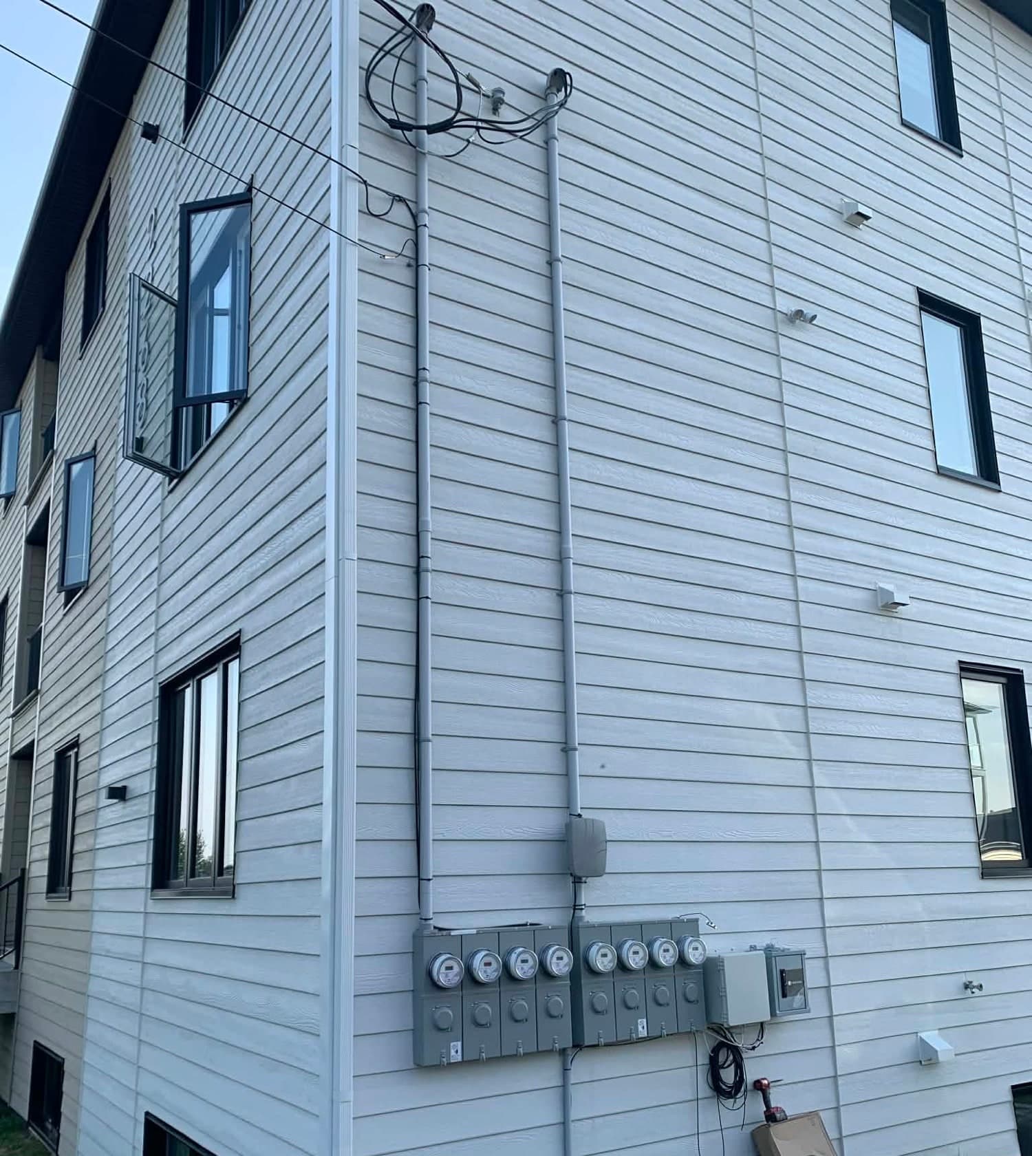 Meter bank and conduits on the outside wall of an apartment building